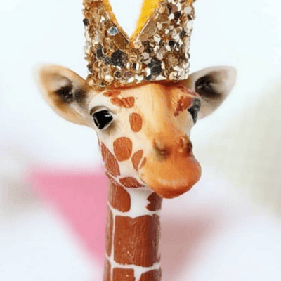Party animal giraffe wearing a gold sparkle crown.