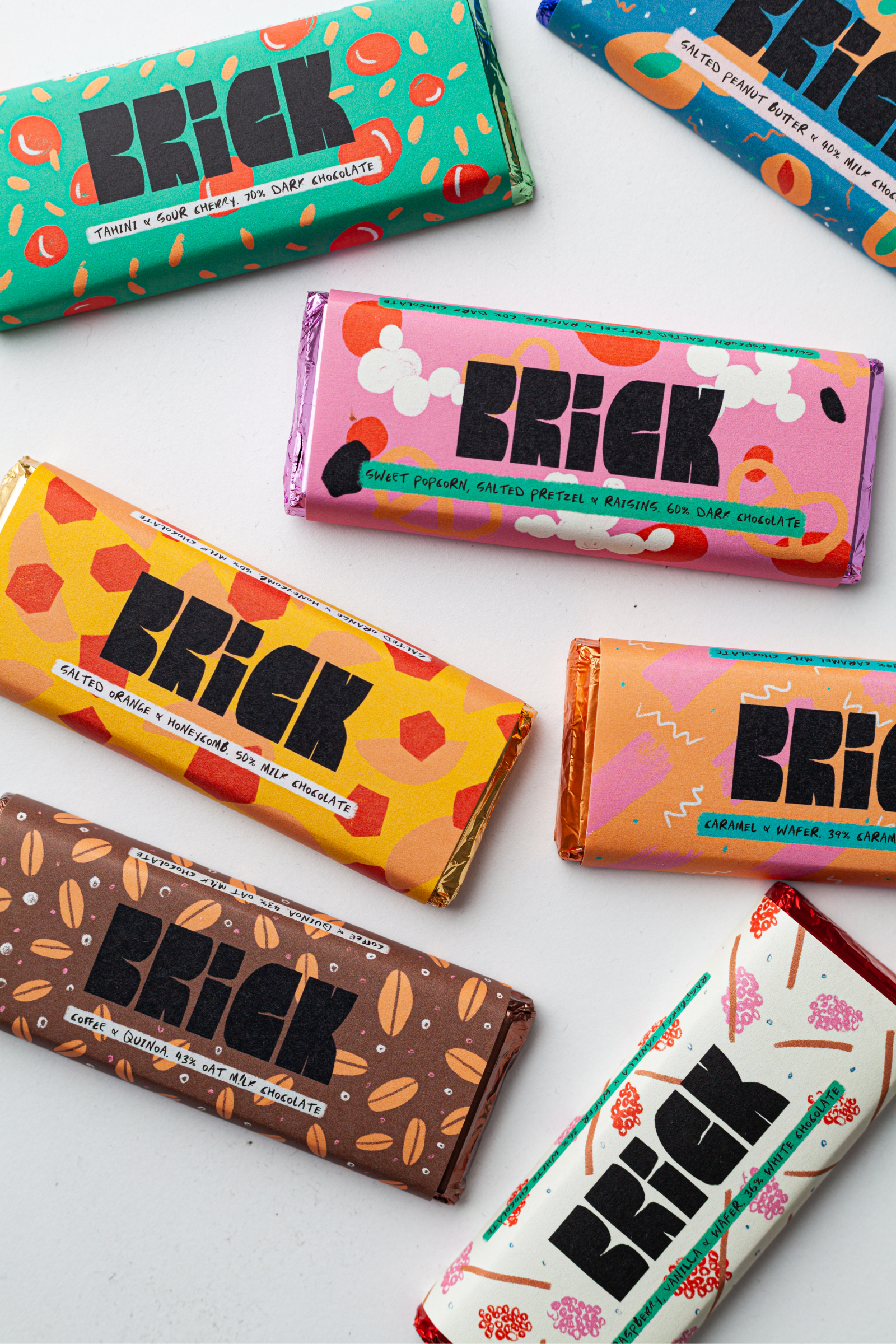 a collection of multi coloured chocolate bars strewn across a table