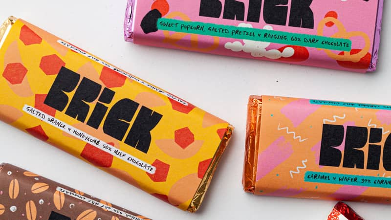 a collection of multi coloured chocolate bars strewn across a table