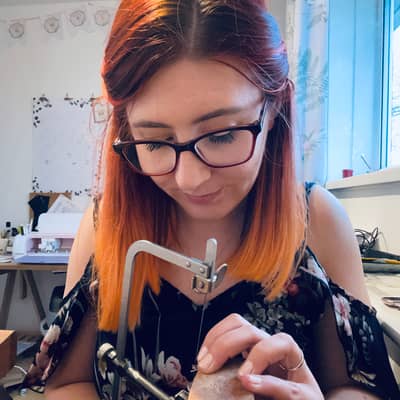 Jen Lithgo - Jen sat at the jeweller's peg, piercing leaves out of sterling silver sheet