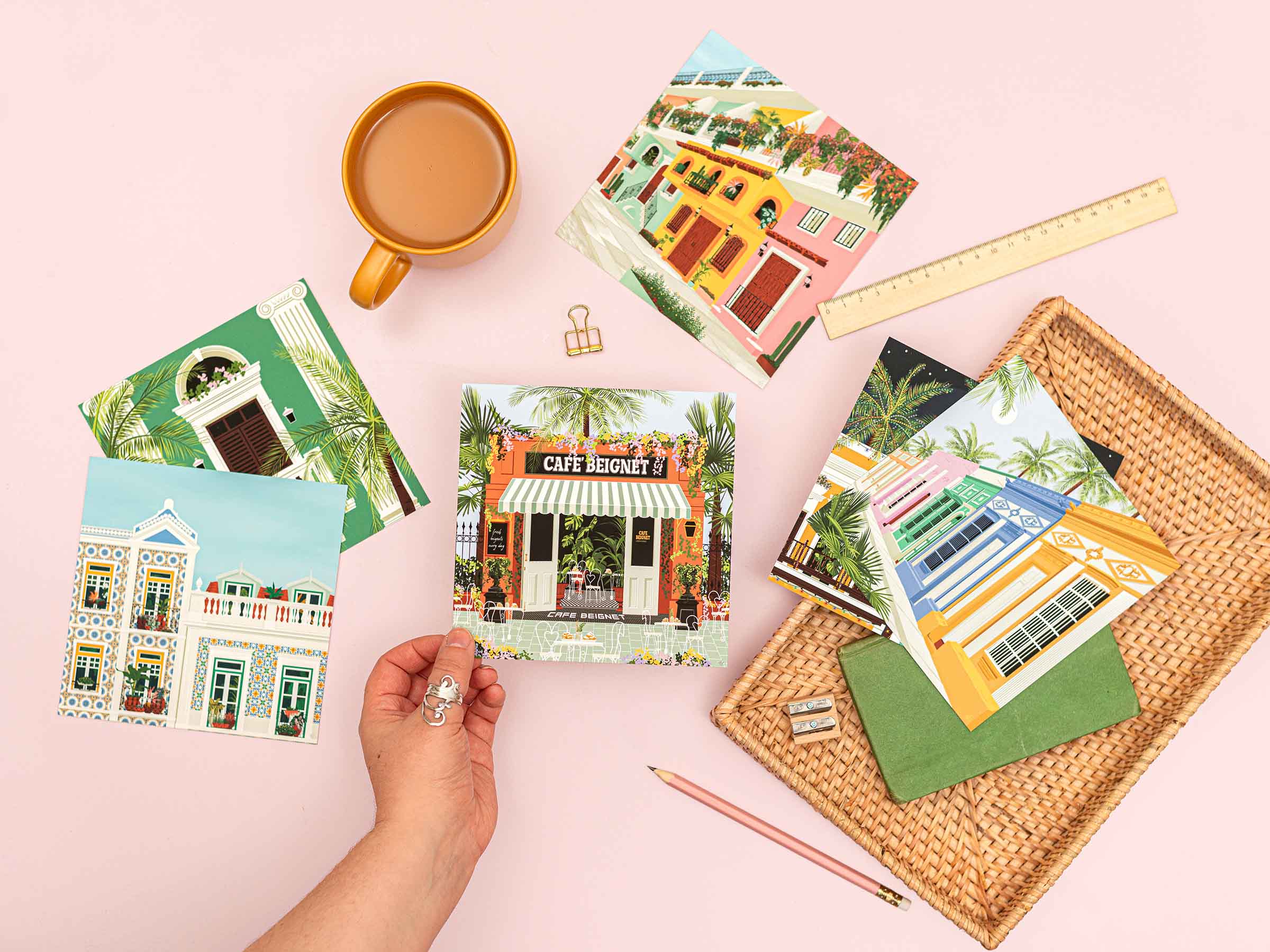 Vero Illustrates holding the Cafe Beignet postcard