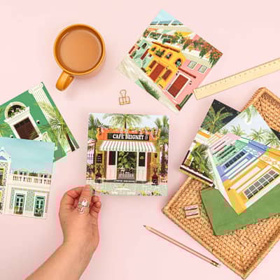 Vero Illustrates holding the Cafe Beignet postcard