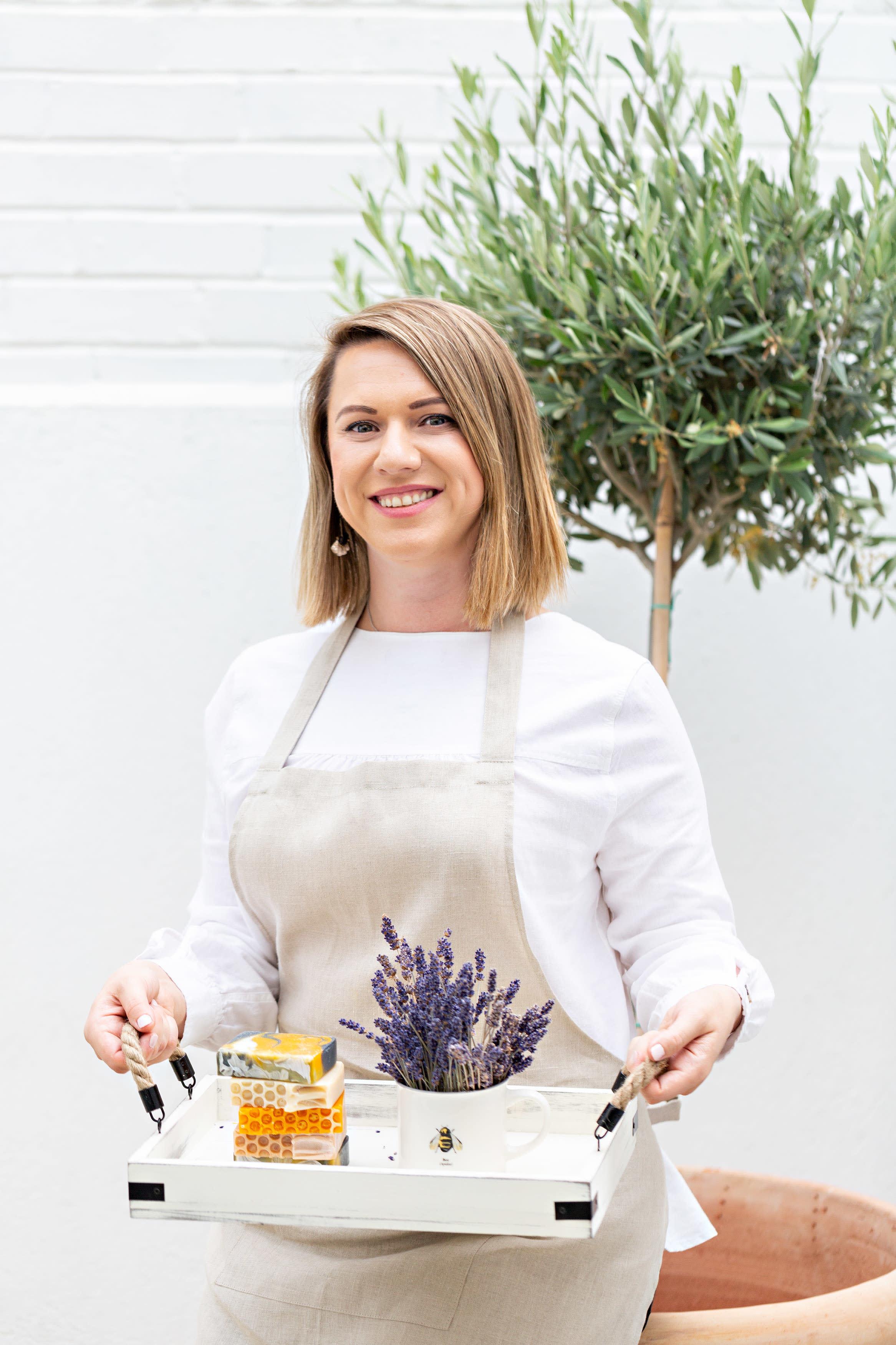 Soapmaker holding a tray of soaps