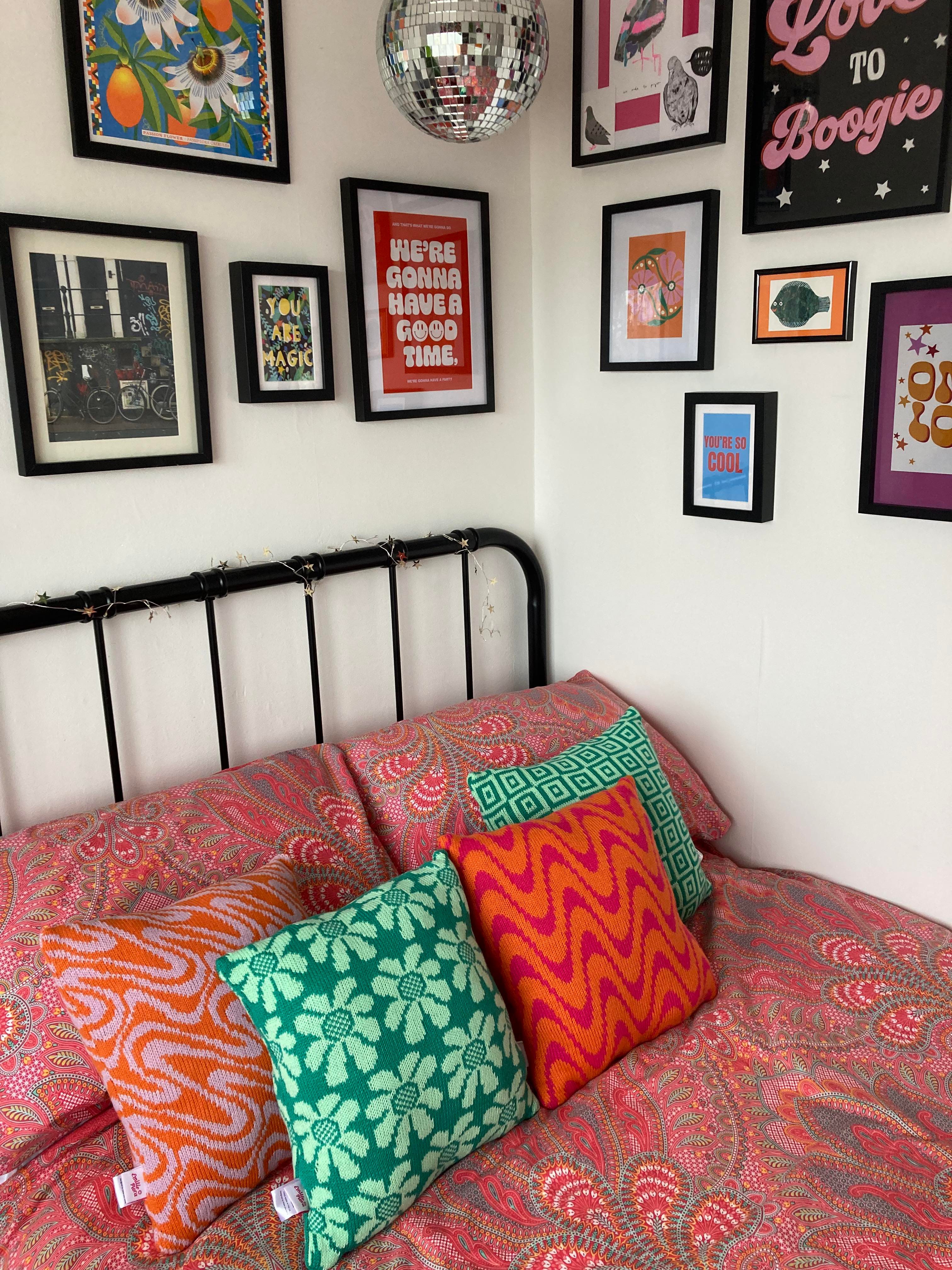 A selection of Emilie Flora cushions styled in a bedroom.