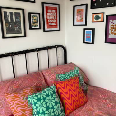 A selection of Emilie Flora cushions styled in a bedroom.