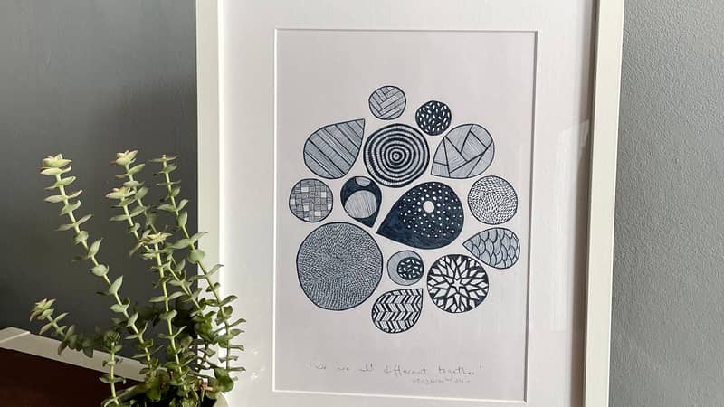 A photo of a framed hand-drawn ink illustration