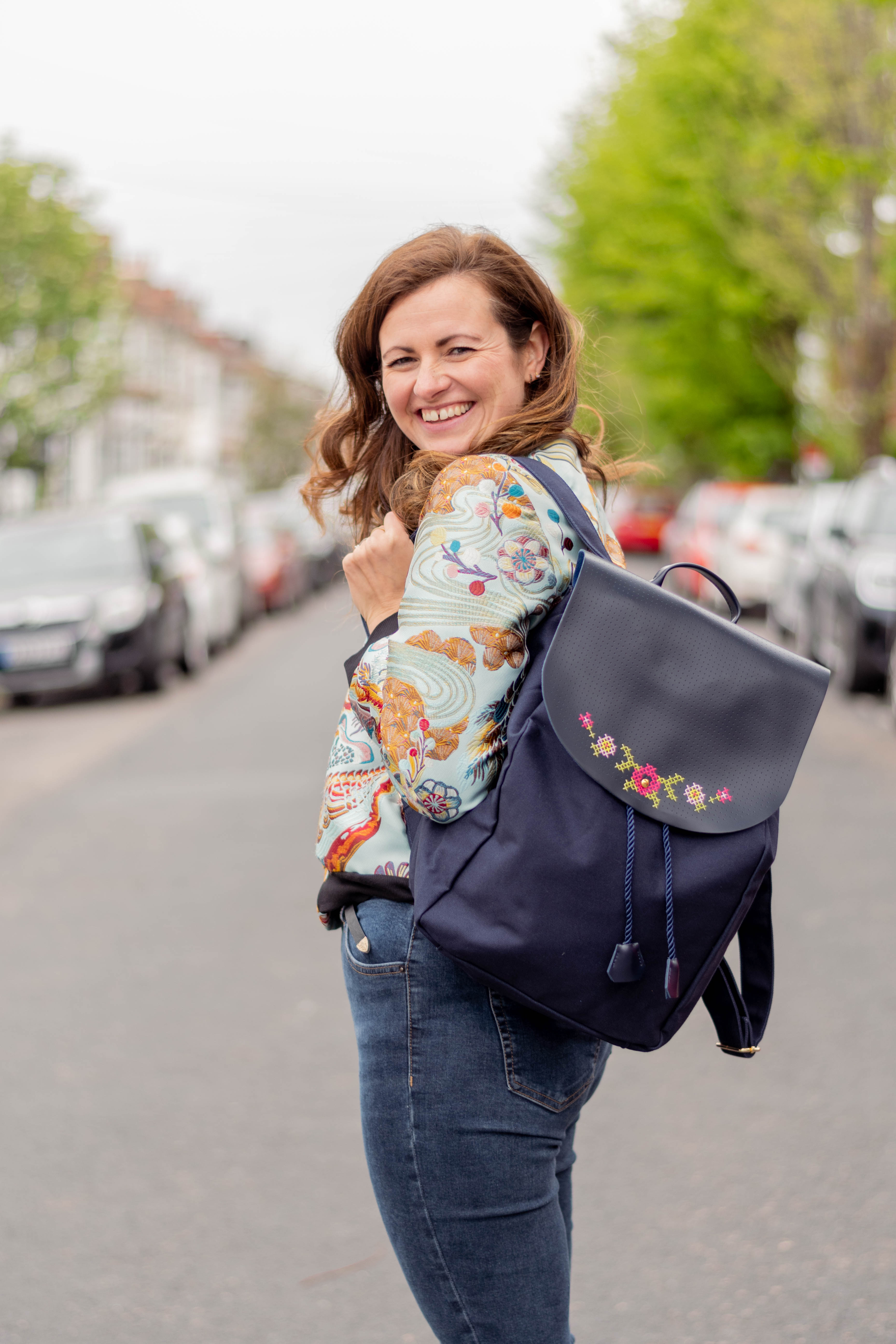 Em Royston founder of Chasing Threads stitching a stitch passport cover in pink leather