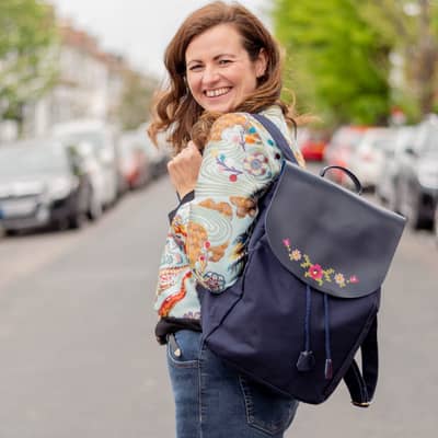 Em Royston founder of Chasing Threads stitching a stitch passport cover in pink leather