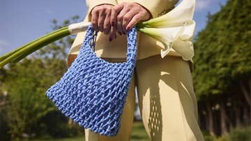 woman holding blue occasion bag