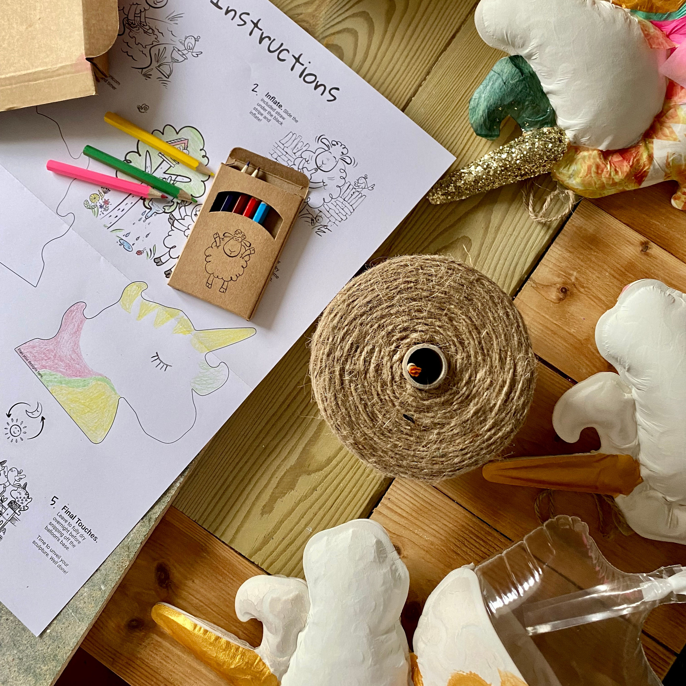 An aerial shot from the workshop looking down on unicorn models and a coloured instructions leaflet.