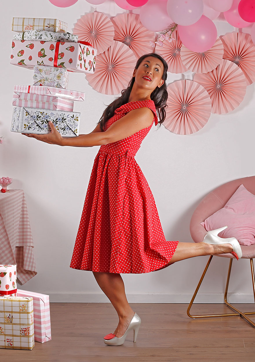 girl holding a pile of making meadows wrapping paper presents
