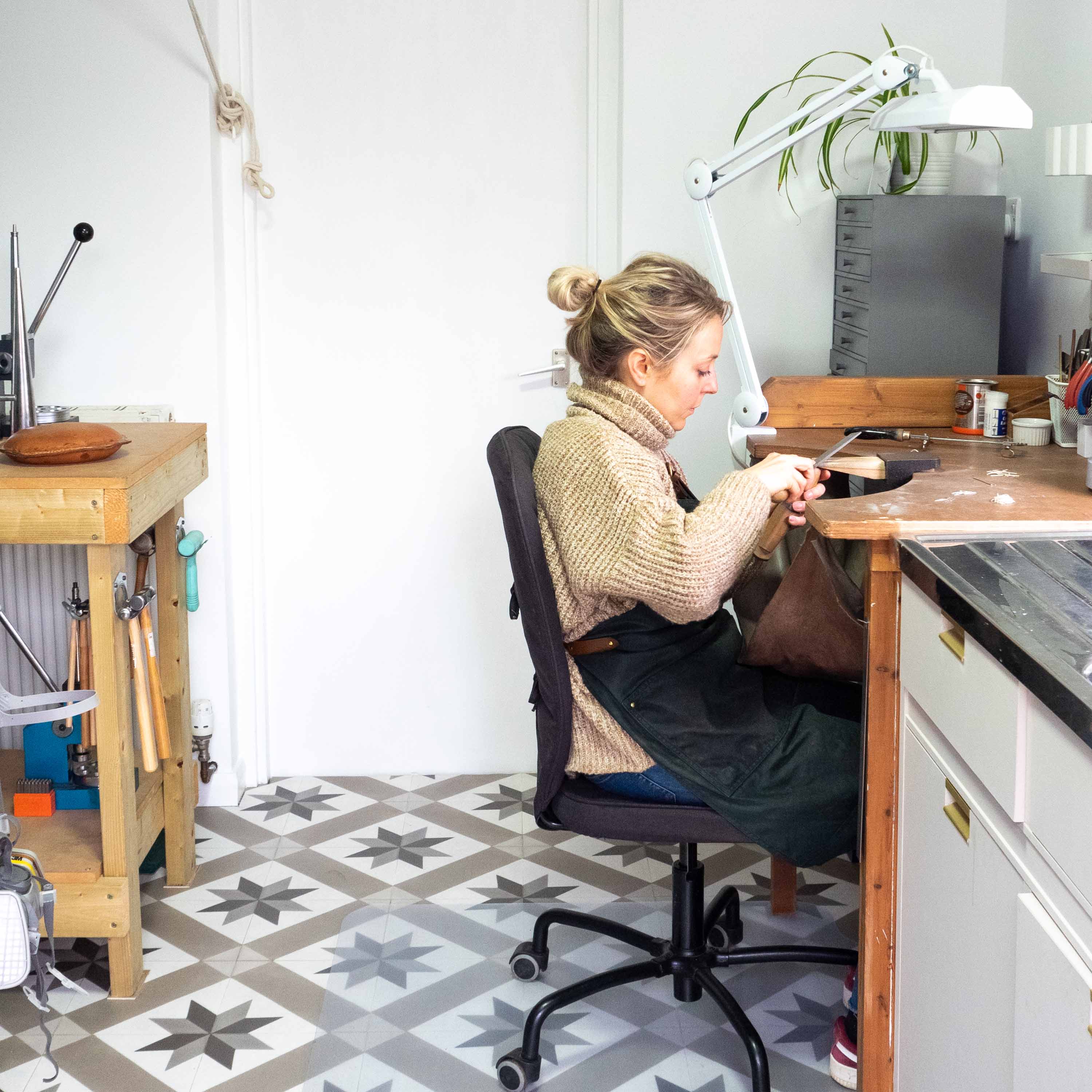 Marion sits making jewellery at her workbench