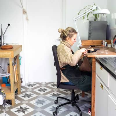 Marion sits making jewellery at her workbench