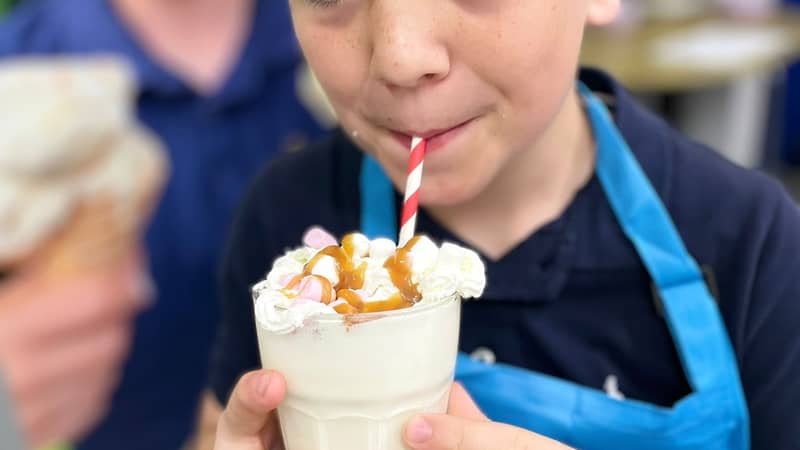 Connor enjoying some gelato ice cream in his chefs hat and apron