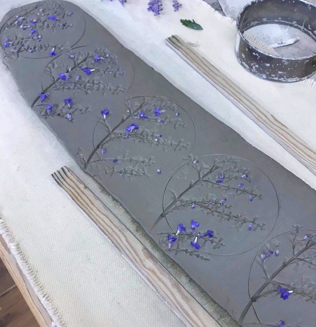 Carefully pressed flowers into clay to make our wild flower coasters.