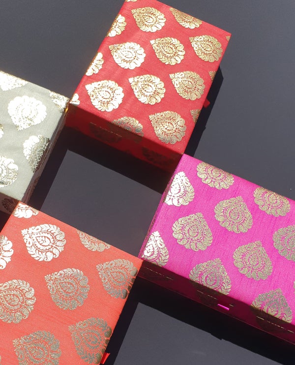 4 coloured indian gift boxes on a black background