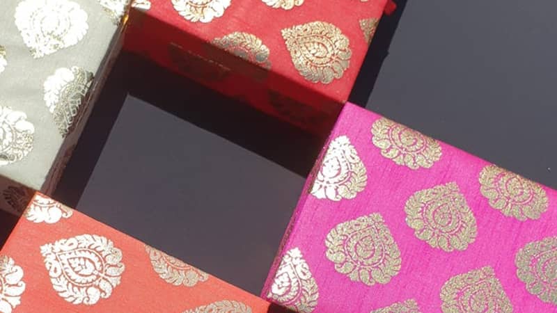 4 coloured indian gift boxes on a black background
