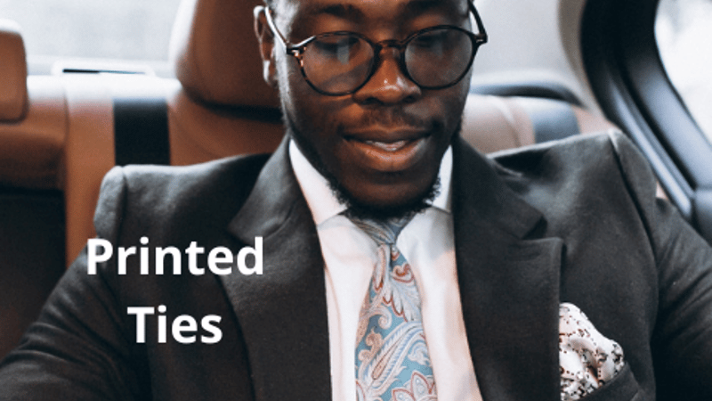 Male model wearing suit and a printed tie.