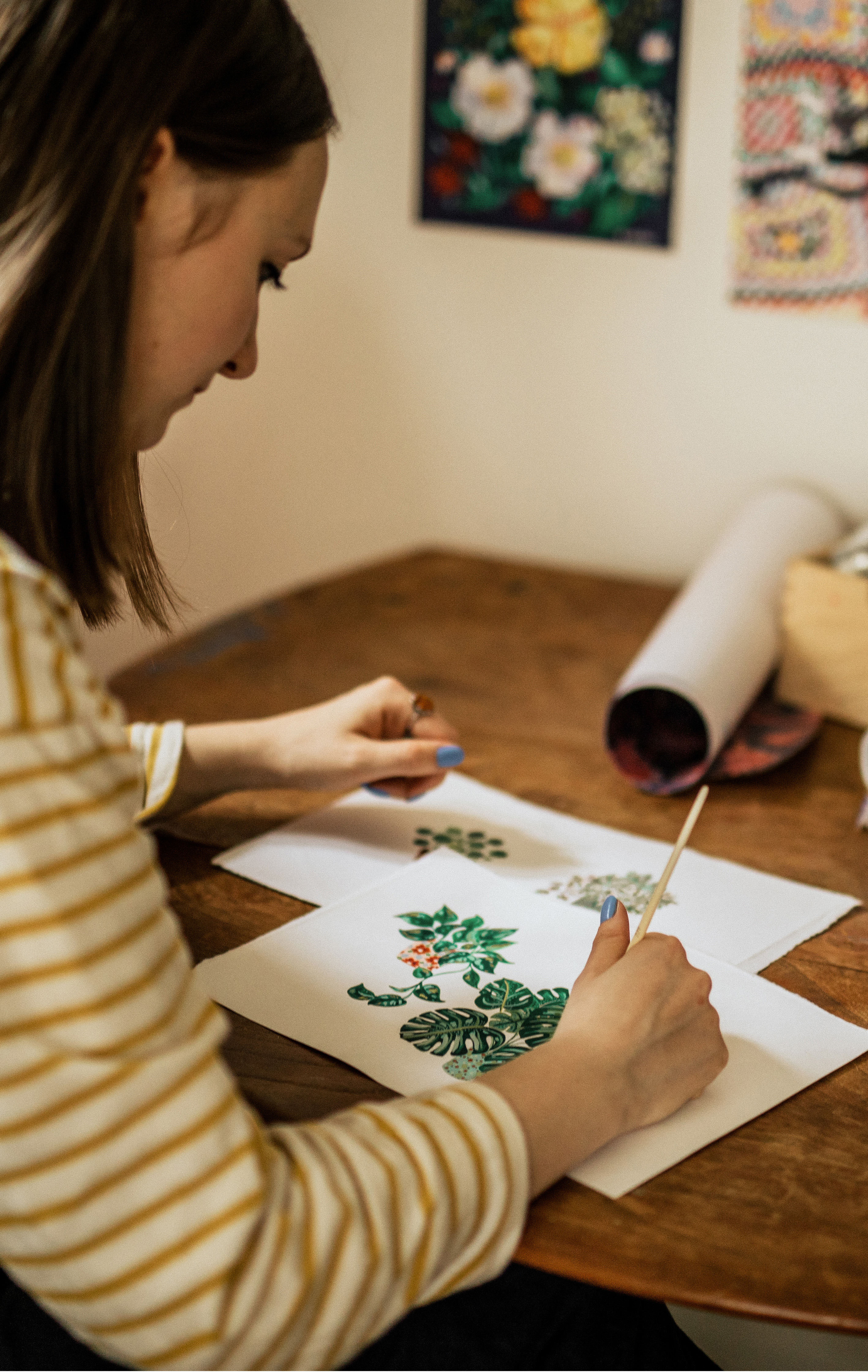 Katie Whitton painting plants at her desk