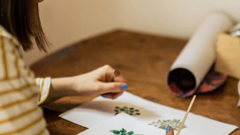Katie Whitton painting plants at her desk