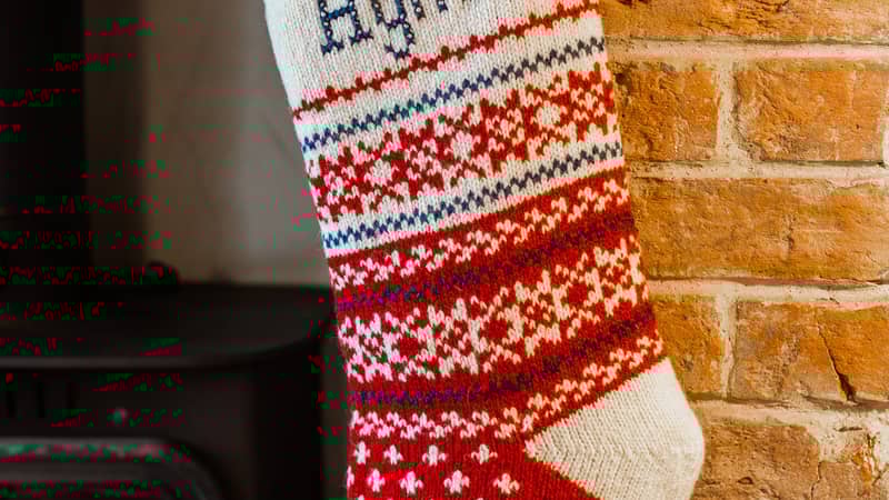 Red and white knitted Christmas Stocking with snowfalkes and hand embroideredd name in cross stitch