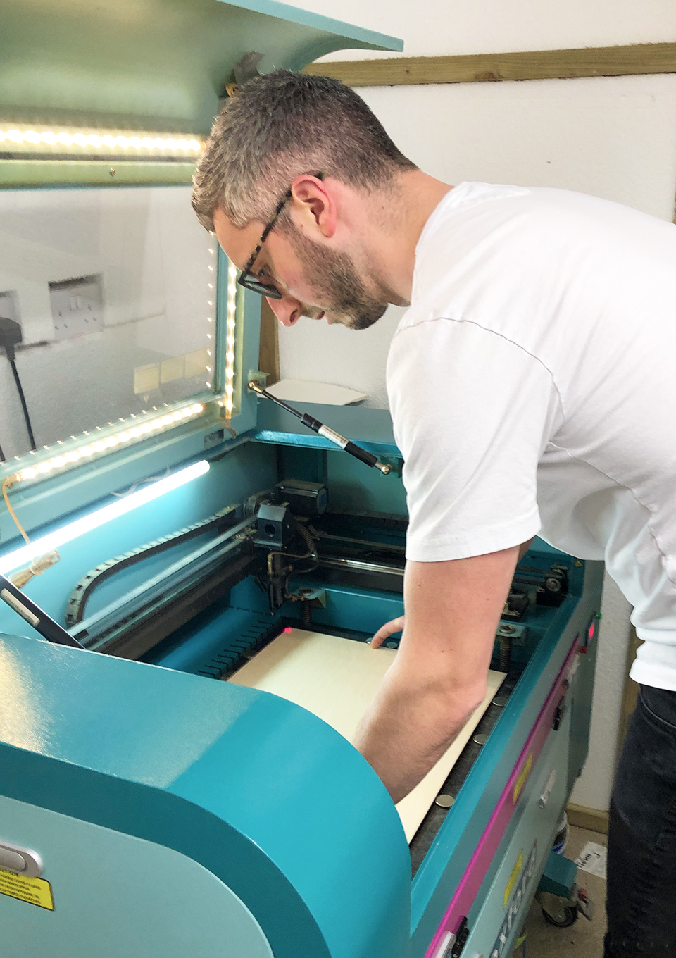 James placing a sheet of plywood into the laser engraver