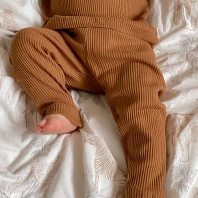 baby legs wearing rust coloured ribbed loungewear set