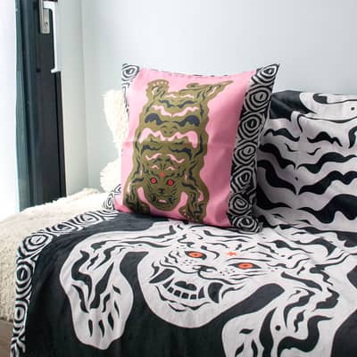 Cosy living room setting with ethnic, boho and tribal style Tibetan tiger printed natural linen cushion and sherpa fleece throw