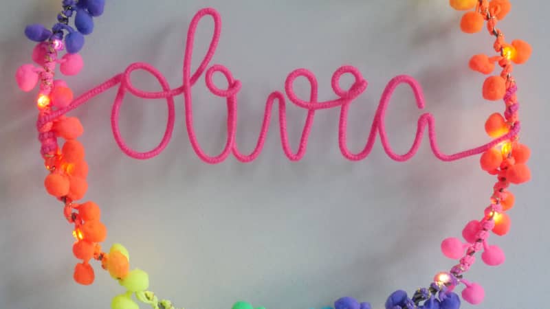 Personalised Aria hoop light with barely blush pom poms and warm grey writing