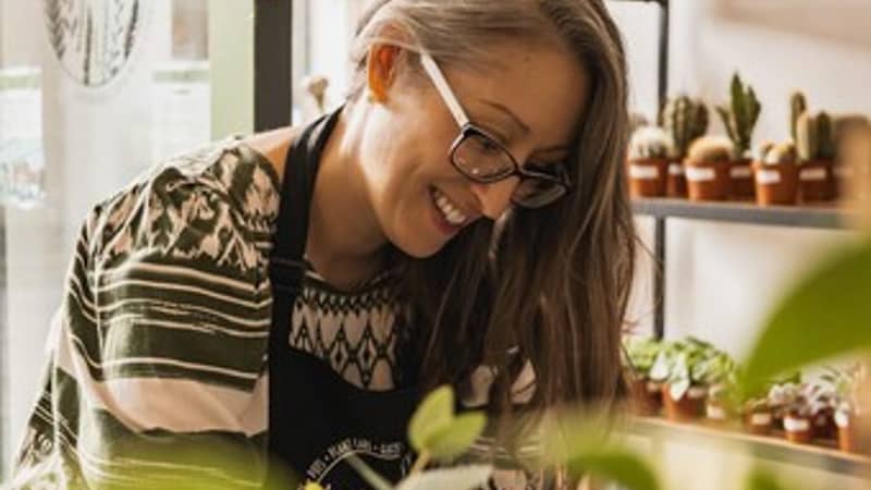A woman tending to plants in a plant shop