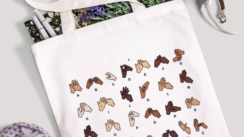 a beautiful white tote back printed with the British Sign Language BSL Alphabet in different skin tones