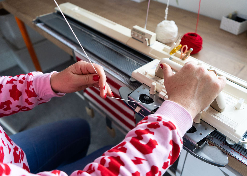 close up of Rosie knitting a striped comforter