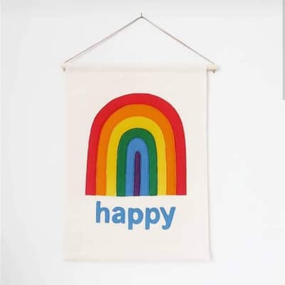 fabric banner on it's own with a tall rainbow stitched on and the word "happy" underneath