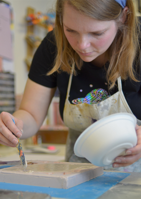 A white woman working with jesmonite in a mould