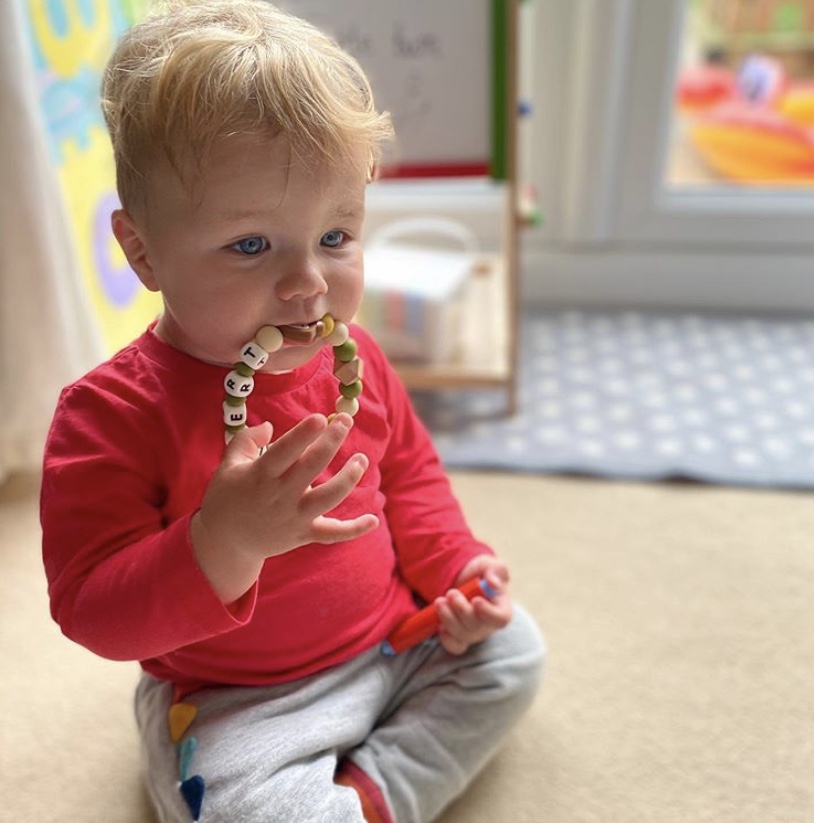 Baby enjoying a Lily & Posie teething ring
