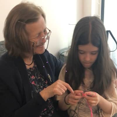 An image of Rejhane, one of the co-founders, teaching her niece to crochet, symbolising a family tradition passed down through generations.