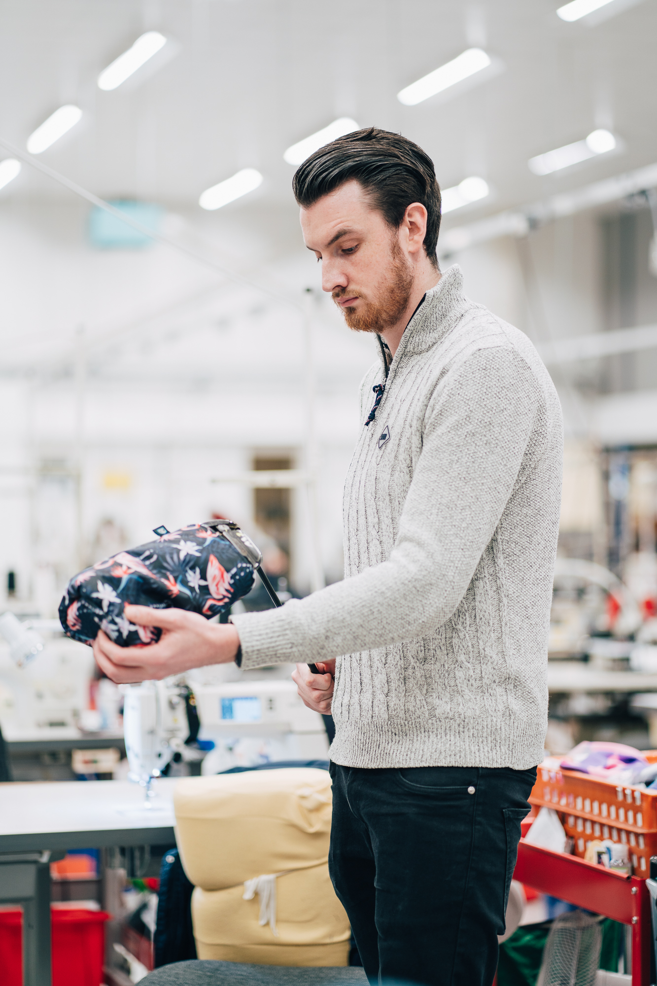Someone putting a driver cover on a club in the factory.