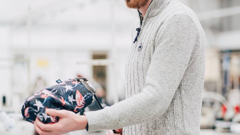 Someone putting a driver cover on a club in the factory.