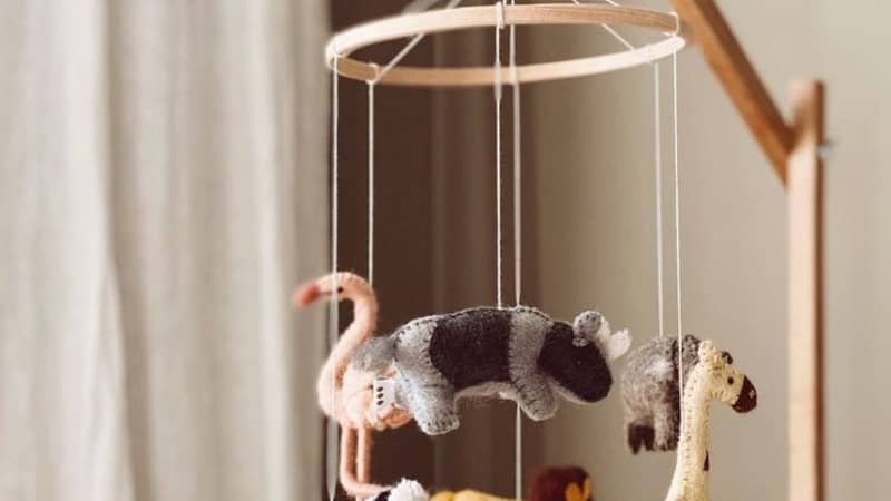 Handmade safari animal baby mobile. A scandi designed baby essential handmade in Nepal featuring 6 animals - a lion, zebra, elephant, giraffe, rhino & flamingo