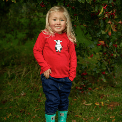 Little girl wearing red cow t-shirt by Cotswold Baby Co