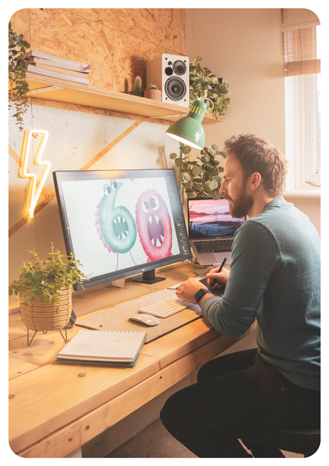 An action shot of Jack in the studio painting a greeting card.