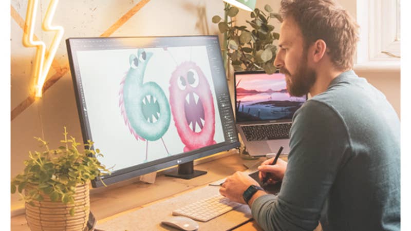 An action shot of Jack in the studio painting a greeting card.