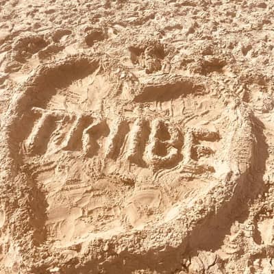 The first attempt by my daughters at our logo. Our swimwear logo drawn in the sand