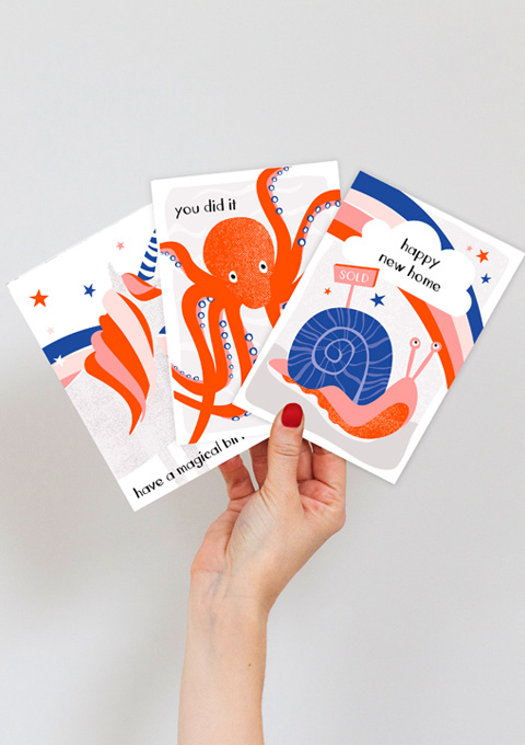 hand holding three designs from rainbow wishes range