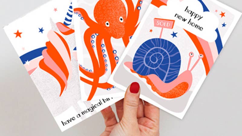 hand holding three designs from rainbow wishes range