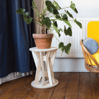 Two Ply-Works Mhor stools stacked together to form a plant stand with houseplant