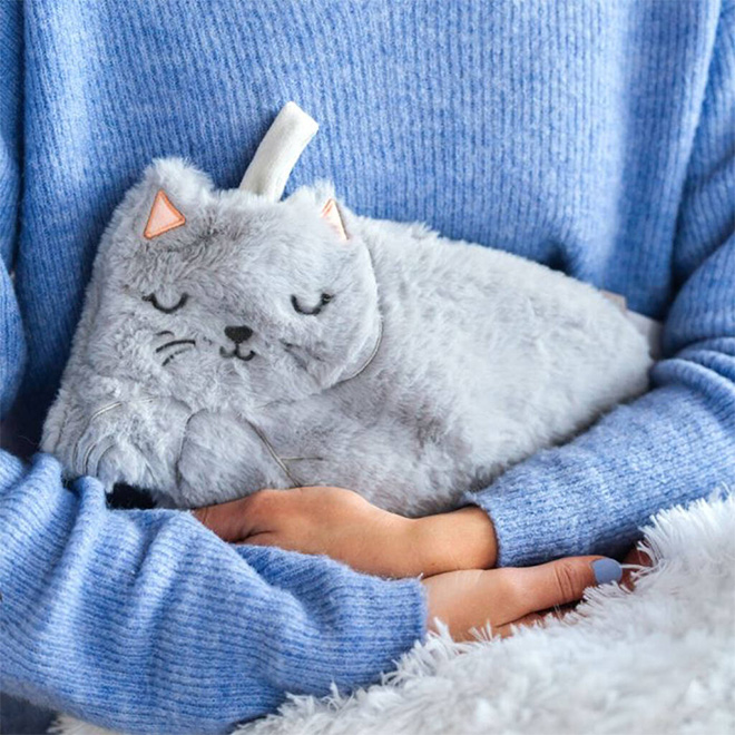 person holding furry cat hot water bottle