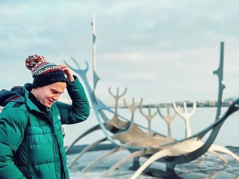 Man wearing a Fairile SuperBobble Hat with a backdrop of snowy Norway