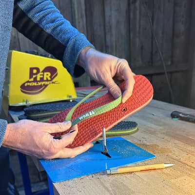 A pair of red and green flip flops being hand made in the UK