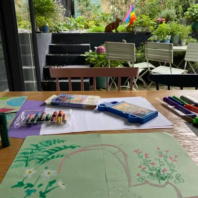 oil pastel drawing on table in front of small London garden view.